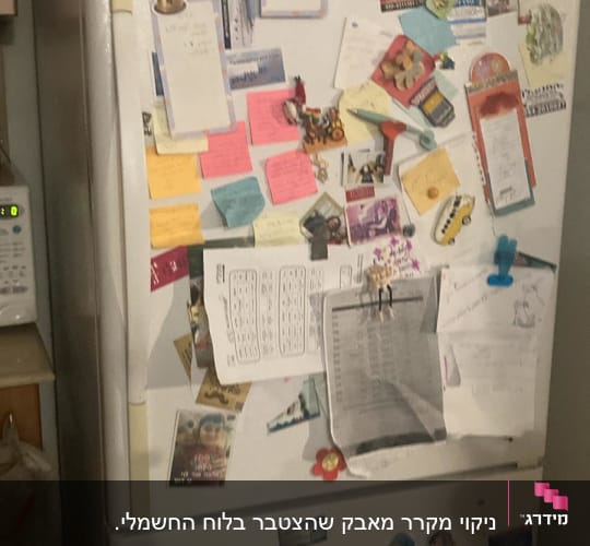 מקרר עם מגנטים, פתקים ותמונות על הדלת